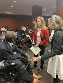 Photo of Stacy Ramirez speaking with people.